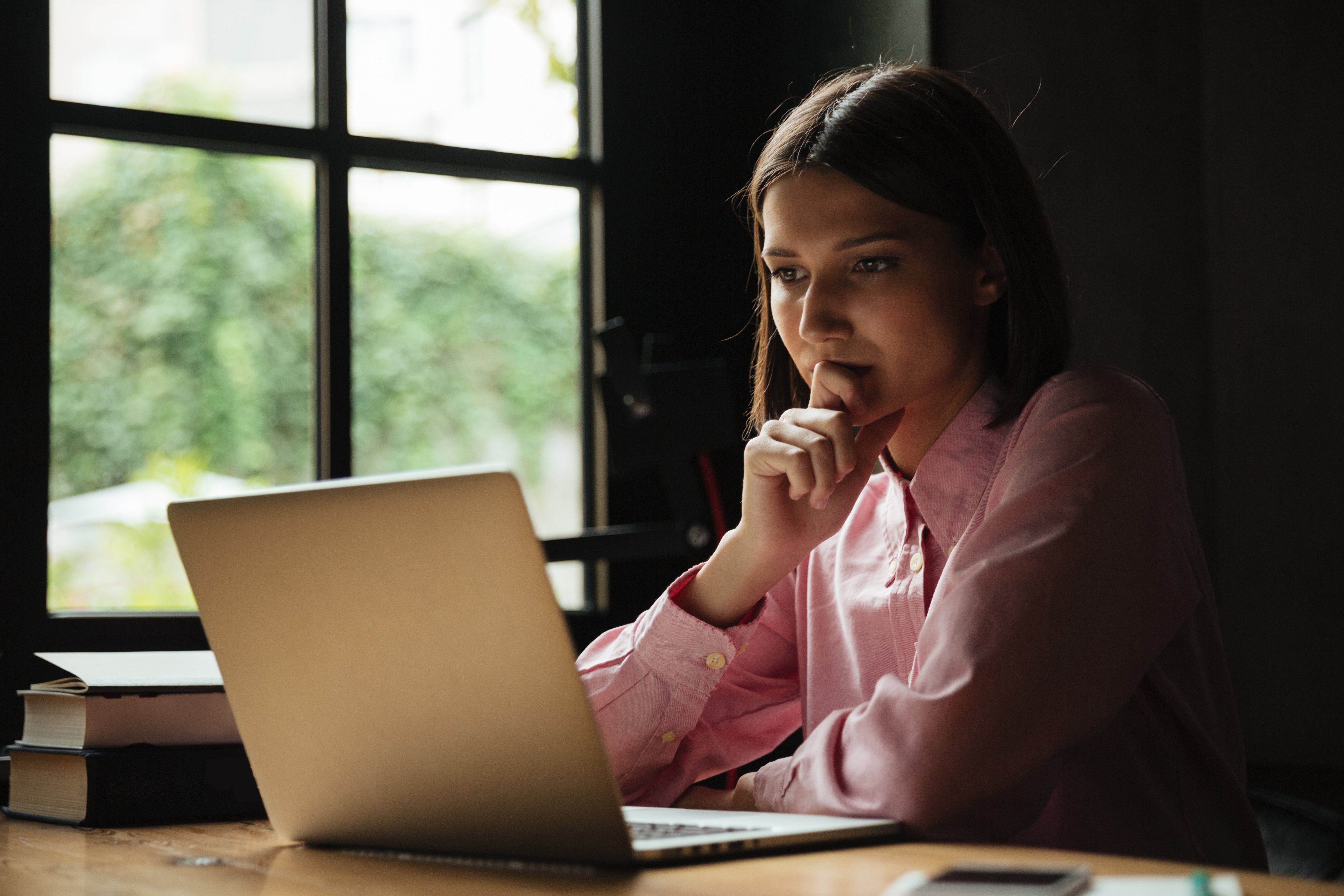 Profissional utilizando celular e notebook em ambiente de trabalho sem integração de PABX em nuvem